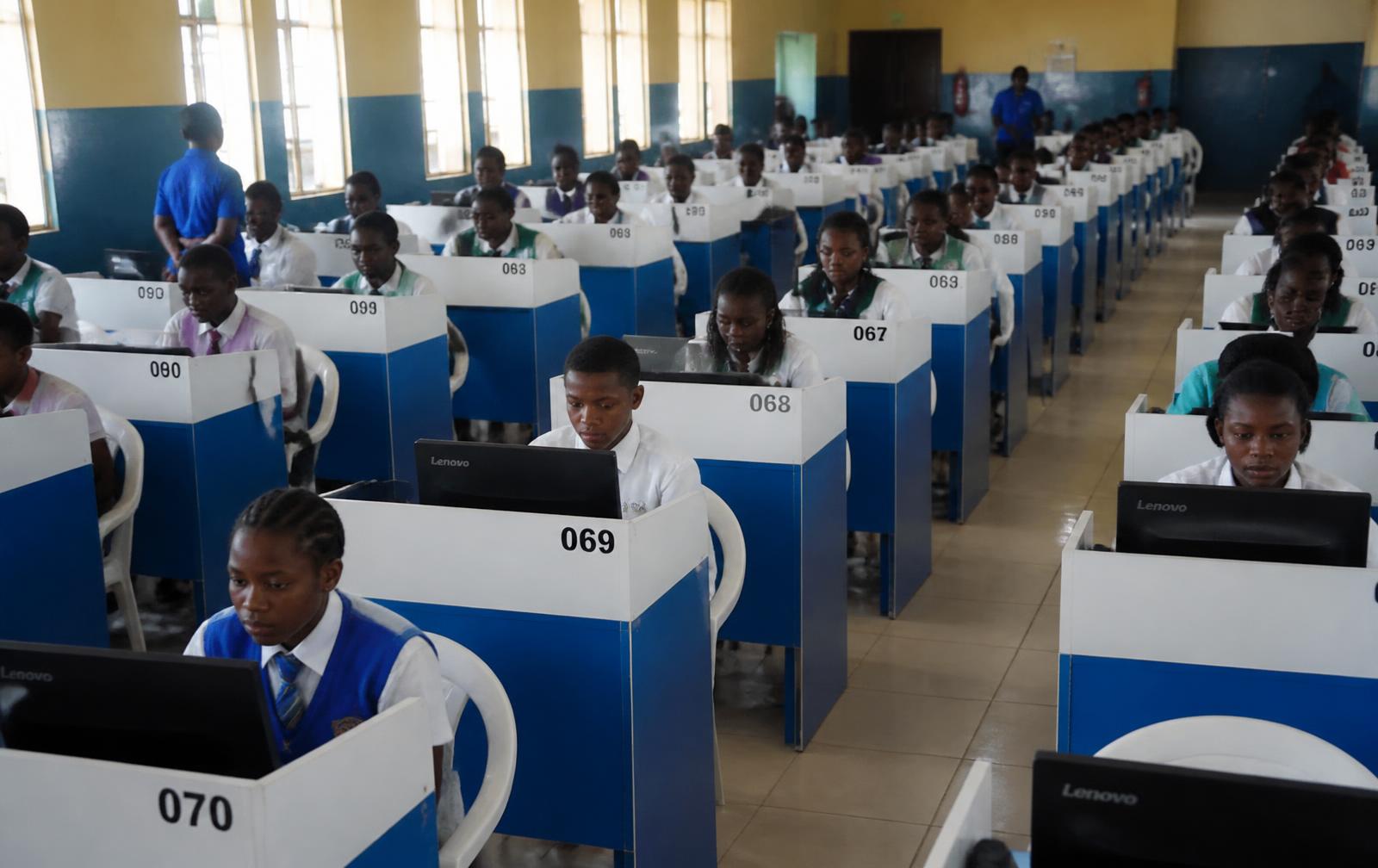 Nigerian UTME candidates seated at numbered CBT terminals in an examination hall